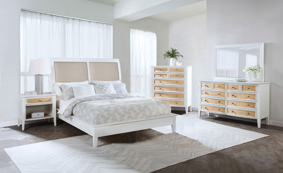 Modern bedroom with a bed, nightstands, dresser, and mirror. In a white walled bedroom