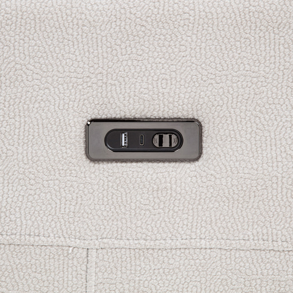 Close-up of a power outlet on a textured light gray surface