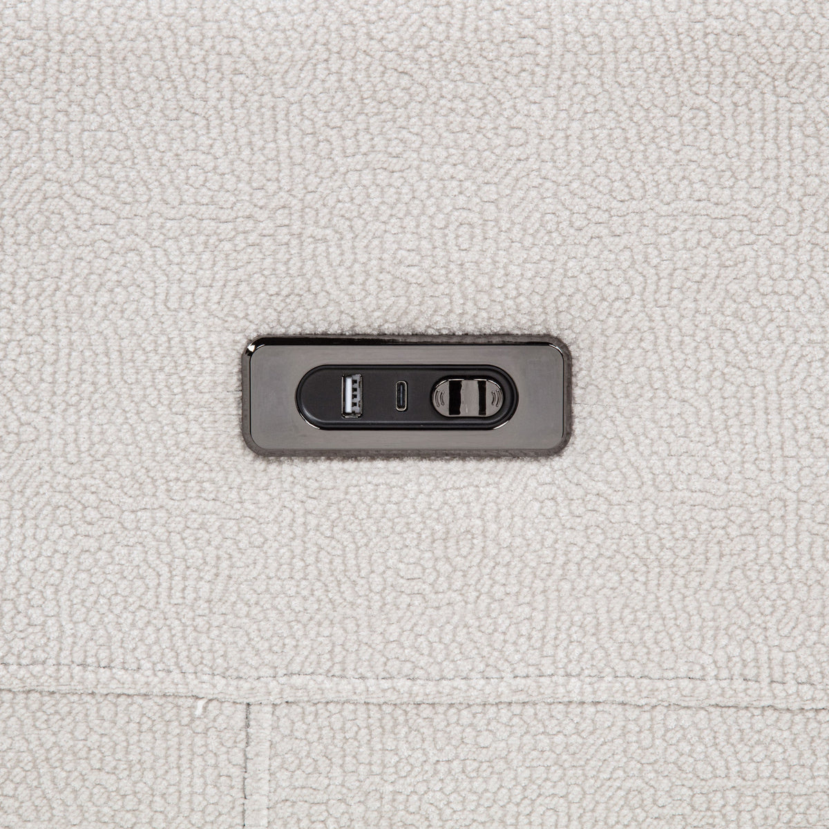 Close-up of a power outlet on a textured light gray surface