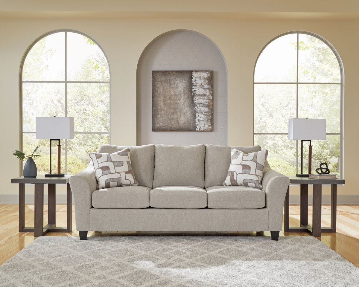 Gray sofa in a living room with arched windows and decorative lamps.