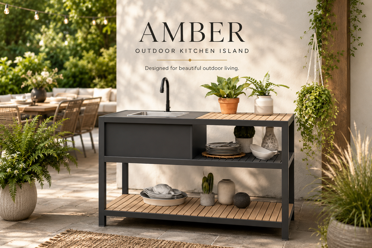 Outdoor kitchen island with a black metal frame and light wood slat top and shelves, set on a patio in front of a white wall with the text 'AMBER OUTDOOR KITCHEN ISLAND'.