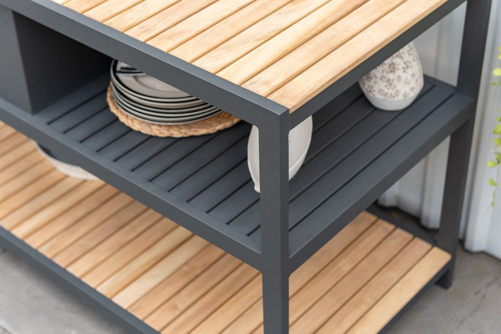 Bakers rack with wooden shelves and a gray metal frame, displaying plates and a vase.