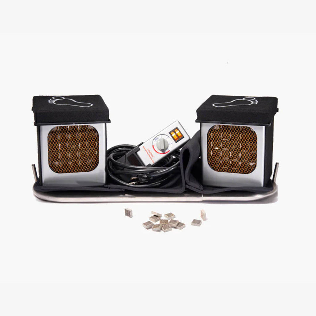 A foot bath kit featuring two black-and-silver heated foot cups with mesh fronts, a central control unit, a black cable, and several small silver ceramic heating elements on a white background.