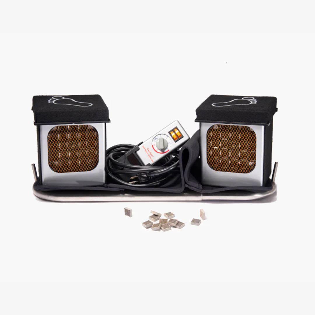 A foot bath kit featuring two black-and-silver heated foot cups with mesh fronts, a central control unit, a black cable, and several small silver ceramic heating elements on a white background.